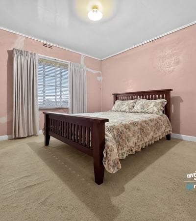 Spacious bedroom featuring natural light, ample storage, and unique wall textures ready for personalization.