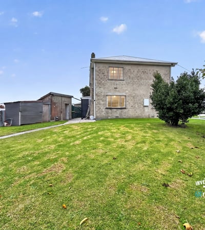 Spacious lot features a two-story home and versatile outbuilding, perfect for renovation or investment opportunities.