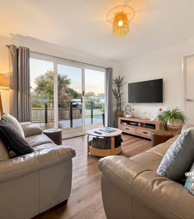 Bright living area features modern furnishings and large sliding doors that open to a scenic outdoor space.