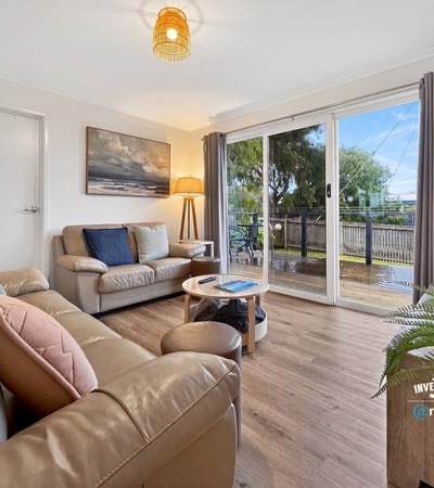 Bright and inviting living space featuring large windows, a cozy atmosphere, and easy outdoor access.
