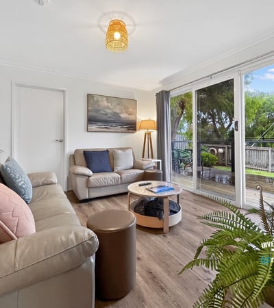 Bright living space featuring large windows that overlook a picturesque outdoor area, perfect for relaxation.