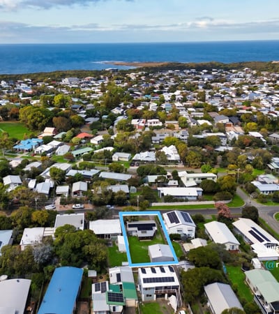 Discover a prime coastal property surrounded by lush greenery and modern homes, just steps from the shoreline.