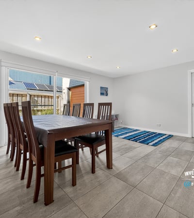 Spacious dining area with abundant natural light, featuring a versatile layout and easy access to outdoor spaces.