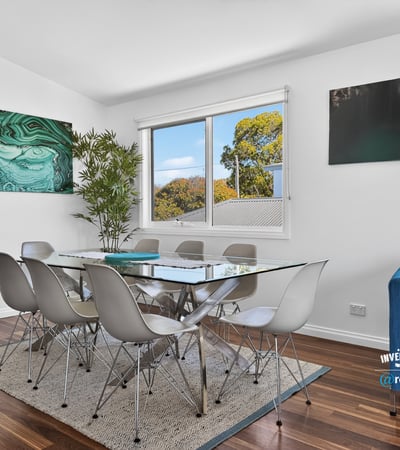 Bright dining area features modern furnishings, large windows, and a contemporary touch, perfect for gatherings.