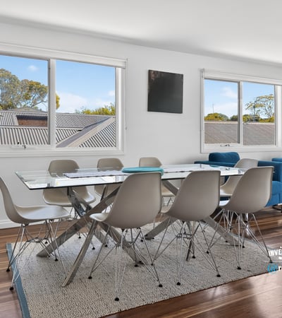 Bright and inviting dining area with large windows, modern furnishings, and beautiful wood flooring.