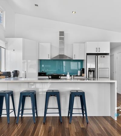 Modern kitchen featuring a striking turquoise backsplash, sleek cabinetry, and ample counter space for entertaining.