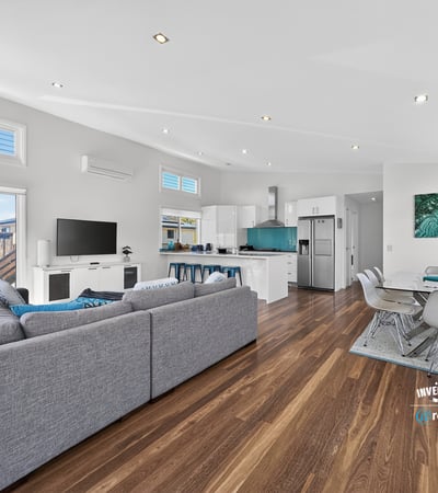 Modern open-plan living space with abundant natural light, featuring a spacious kitchen and inviting entertainment area.