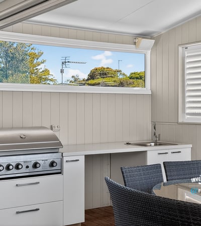 This outdoor entertaining space features a built-in grill and modern kitchen perfect for gatherings.