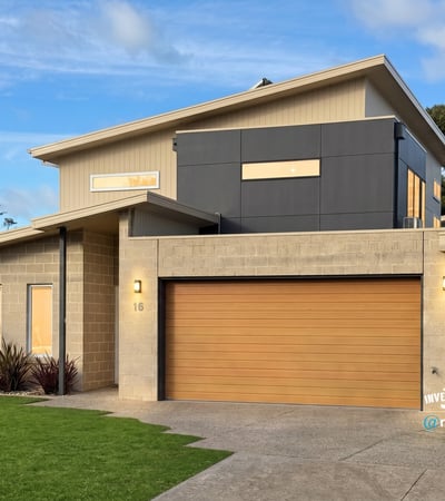 Contemporary home featuring unique architectural design, spacious garage, and vibrant landscaping in a desirable neighborhood.