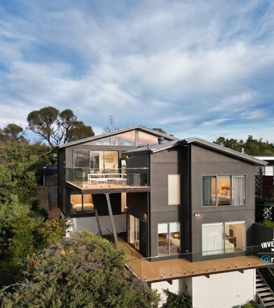 Contemporary home nestled in nature, featuring expansive decks and large windows that invite abundant natural light.