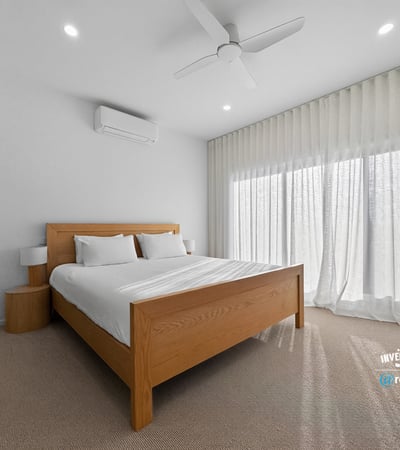 Bright and airy bedroom featuring large windows, modern furnishings, and ample natural light.