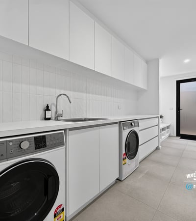 Modern laundry space featuring sleek cabinetry, high-efficiency appliances, and ample storage for convenience.