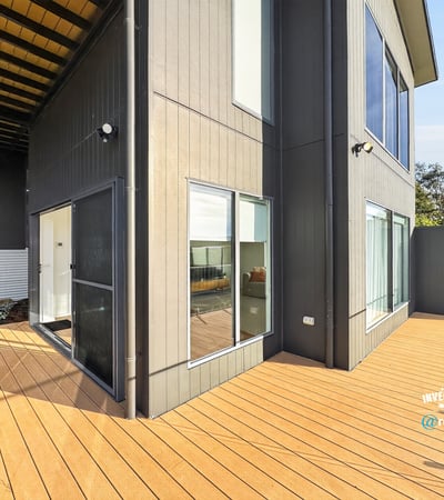 Modern home featuring a spacious outdoor deck and large windows, perfect for entertaining and natural light.