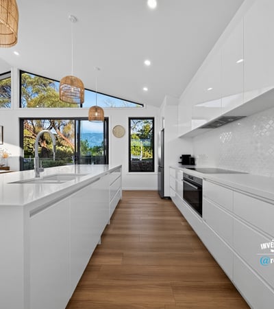 Modern kitchen featuring sleek cabinetry, ample natural light, and scenic views, perfect for culinary enthusiasts.