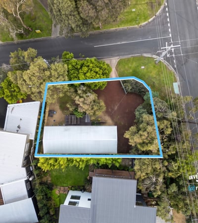 Spacious lot featuring a prime location near a main intersection, surrounded by lush greenery.
