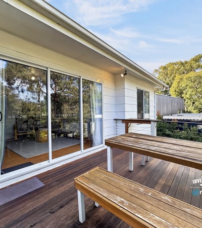 Bright outdoor space featuring a spacious deck, perfect for gatherings and enjoying the surrounding greenery.