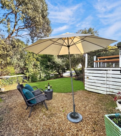 Inviting outdoor space features a shaded seating area, perfect for relaxation or entertaining amid lush greenery.