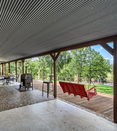 Spacious covered porch offers panoramic nature views, perfect for outdoor gatherings and relaxation.