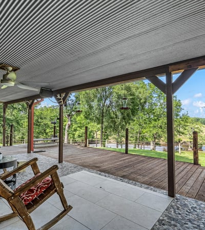 Spacious covered porch overlooking lush greenery, perfect for relaxation and outdoor gathering opportunities.