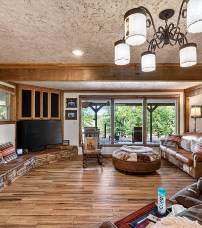 Spacious living area features a cozy layout with natural light, rich textures, and ample seating for gatherings.