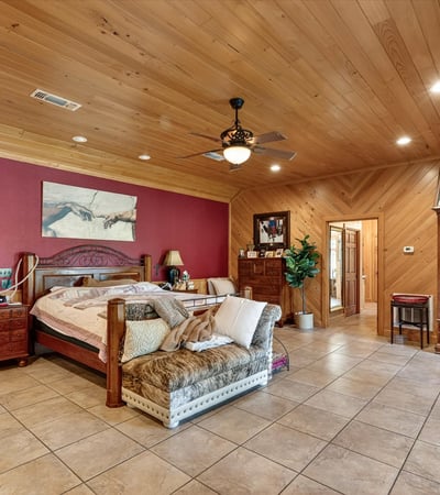 Spacious master bedroom featuring warm wood accents and ample natural light, perfect for relaxation and retreat.