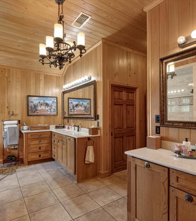 Spacious bathroom with natural wood accents, dual vanities, and a soaking tub for relaxation.