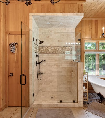 This luxurious bathroom features a spacious walk-in shower and a freestanding tub, surrounded by natural light.