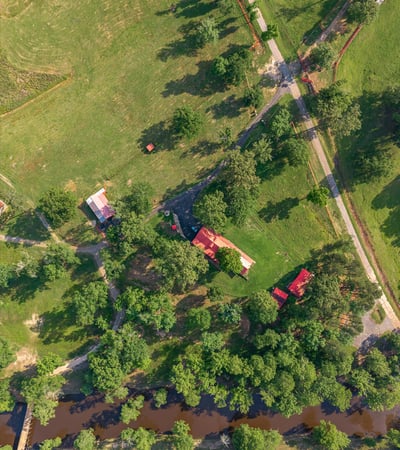 Discover a picturesque property featuring lush greenery, a winding river, and ample space for outdoor activities.
