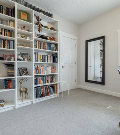 Bright study with built-in bookshelves, ample storage, and plenty of natural light for productivity.