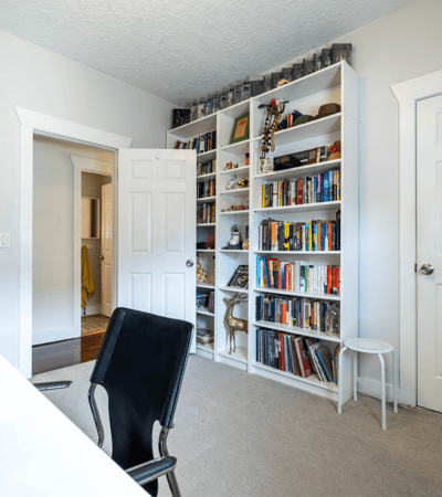 Bright and inviting room featuring a spacious bookshelf and a comfortable workspace, perfect for productivity.