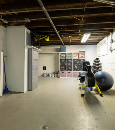 Spacious unfinished basement featuring ample room for storage and home fitness equipment, ideal for customization.