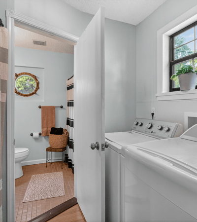 Bright and functional laundry area seamlessly connecting to a full bathroom.