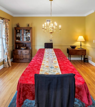 Dining Room has gleaming hardwood flooring. Afternoon sun streams through double windows.