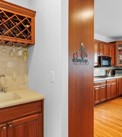 Butlers Pantry with convenient wine rack, glassware storage, wet bar, and prep area.