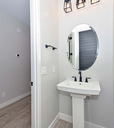 This well-appointed powder room blends modern design with bold light fixtures and clean lines perfect for guests and daily use.