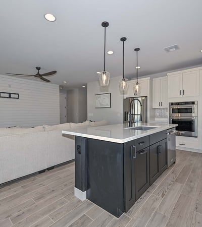 The kitchen offers unobstructed views into the great room, featuring pendant lighting, sleek finishes, and plenty of prep space on the oversized island.