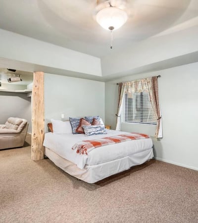 Bedroom paired with adjacent lounge space, featuring log columns and open flow ideal for guests or multi-generational living.