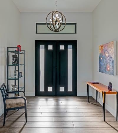 The foyer welcomes guests with updated tile flooring, designer lighting, and contemporary Scottsdale design details.