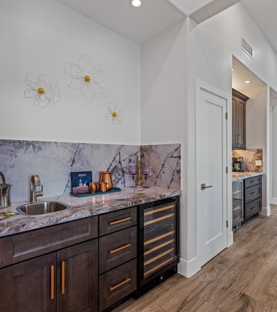 Elegant wine bar with cabinetry, marble accents, and storage creates a functional feature for Scottsdale entertaining.