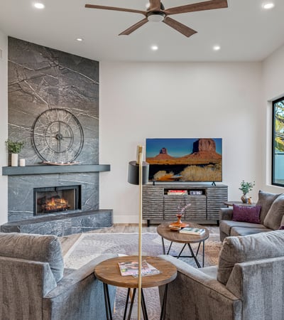 A welcoming family room with stone fireplace, large windows, and stylish finishes offers comfort and charm in Scottsdale.