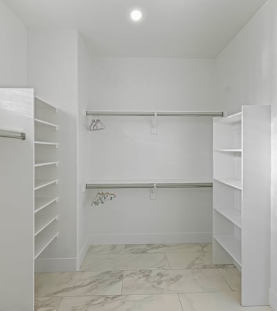 Bright walk-in closet with shelves and hanging space provides practical storage and convenience.