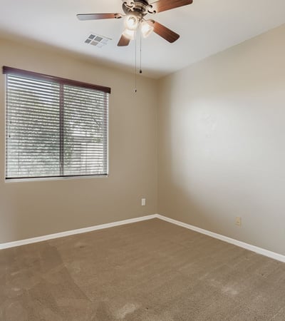 Flexible third bedroom with neutral tones and natural light ideal for children, office space, or guests.