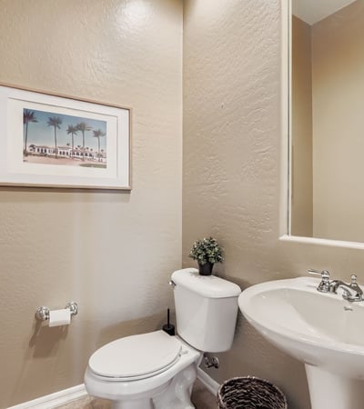 Convenient powder bath with bright finishes and updated fixtures enhances guest comfort in this Peoria property.