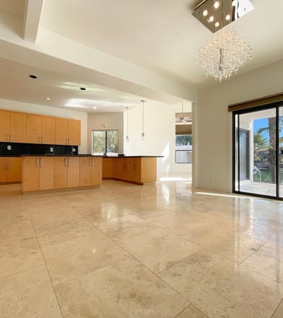 Bright kitchen-dining area with elegant tile floors, crystal lighting, and sliding doors opening to waterfront views ideal for entertaining in style.