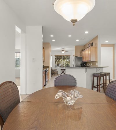 Sun-filled dining area with open access to the kitchen and living room, creating a perfect flow for entertaining and casual dining in this stunning Surprise home.