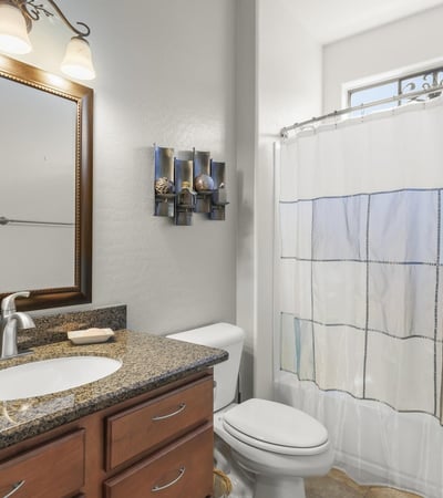 Granite counters, updated fixtures, and a framed mirror add a touch of elegance to this functional, modern guest bath.
