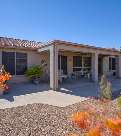 The large covered patio provides shade and comfort for outdoor dining or lounging. Surrounded by vibrant desert plants and private views.