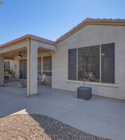 An extended patio designed for entertaining with ceiling fan, lighting, and plenty of space for seating under the Arizona sky.