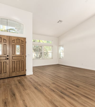 Bright Scottsdale living room with vaulted ceilings, wide windows, and modern flooring that enhances the open layout. Natural light fills the space, creating an inviting atmosphere perfect for everyday living.