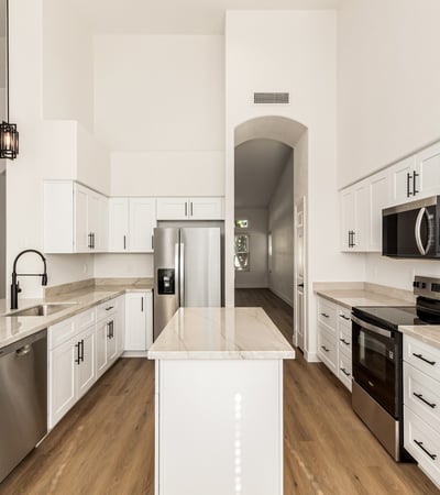 Beautiful center view of the remodeled Scottsdale kitchen showcasing clean cabinetry, stainless steel appliances, and a large center island. The open design makes this kitchen ideal for both cooking and entertaining.